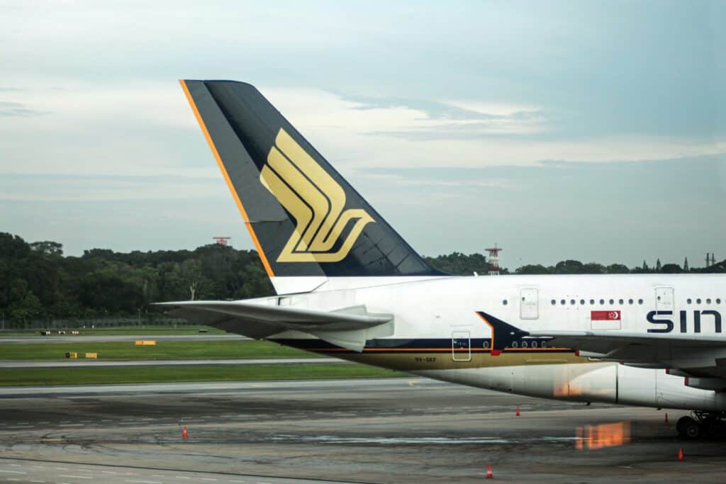 Singapore Airlines aircraft tail fin on runway with logo clearly visible